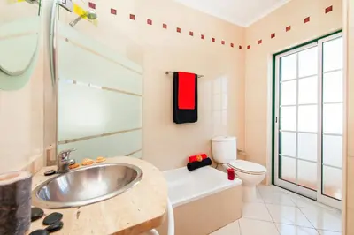 a bathroom with a sink and a tub and a toilet at Villa Saona by Algarve Vacation in Albufeira