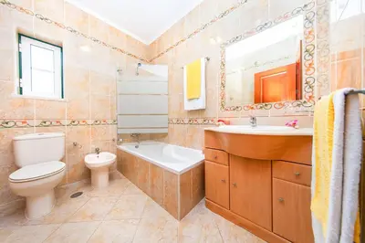 a bathroom with a toilet and a sink and a mirror at Villa Saona by Algarve Vacation in Albufeira