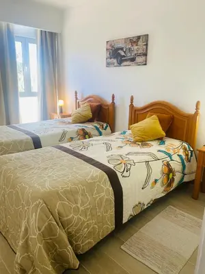 two beds sitting next to each other in a bedroom at Apartamento relaxante com terraço e próximo da praia, no 2º andar in Quarteira