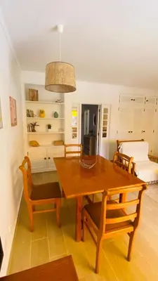 a dining room with a wooden table and chairs at Apartamento relaxante com terraço e próximo da praia, no 2º andar in Quarteira