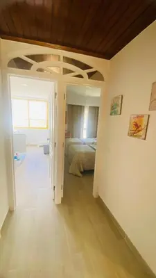 a bedroom with a bed and a room with a door at Apartamento relaxante com terraço e próximo da praia, no 2º andar in Quarteira