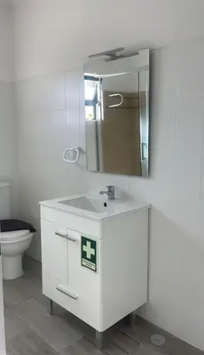 a bathroom with a sink and a mirror and a toilet at Quarteira-Your Seaside Getaway in Quarteira