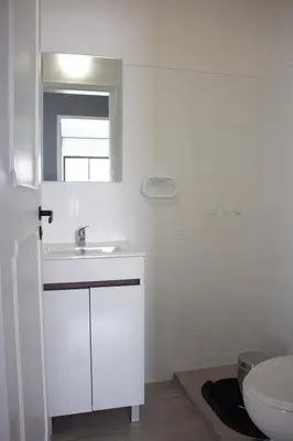 a white bathroom with a sink and a toilet at Quarteira-Your Seaside Getaway in Quarteira