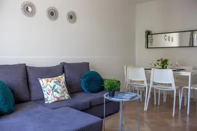 a living room with a couch and a table and chairs at Quarteira-Your Seaside Getaway in Quarteira