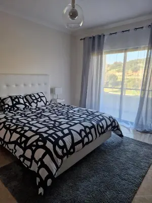 a bedroom with a black and white bed and a window at Holiday home in Albufeira in Albufeira