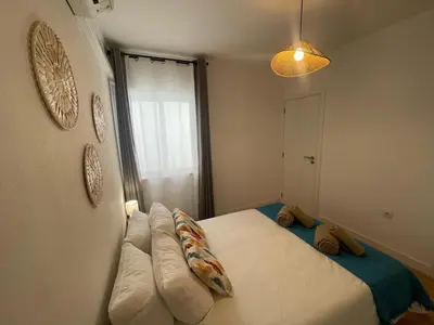 a bedroom with a bed with pillows and a window at Casa da Baixa in Faro