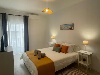 a bedroom with a bed with orange and green pillows at Casa da Baixa in Faro