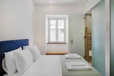 a bedroom with a bed with white pillows and a window at Faro DAZ House by Get Your Stay in Faro