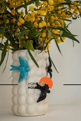a white vase with a bouquet of flowers in it at #294 T2 Com Amplo Terraço by Home Holidays in Albufeira