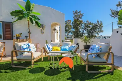 a patio with two chairs and a table on grass at #294 T2 Com Amplo Terraço by Home Holidays in Albufeira