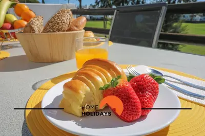 a plate of bread and strawberries on a table at #294 T2 Com Amplo Terraço by Home Holidays in Albufeira