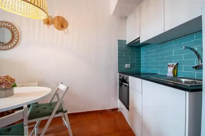 a small kitchen with a sink and a table at BeGuest Vila Magna Apartment in Albufeira