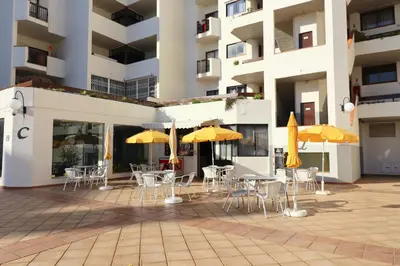 an outdoor patio with tables and chairs with umbrellas at BeGuest Vila Magna Apartment in Albufeira