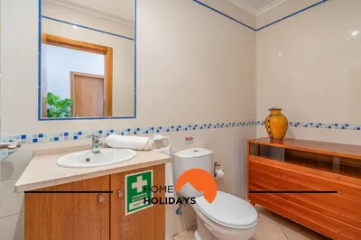 a bathroom with a toilet and a sink and a mirror at #298 Villas Luz H by Home Holidays in Albufeira