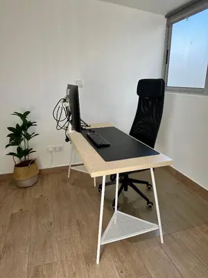 a desk with a computer and a chair in an office at Beach, please! in Quarteira
