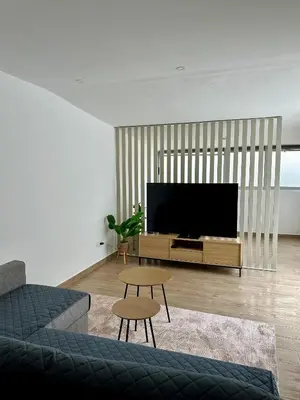 a living room with a tv and a couch and a table at Beach, please! in Quarteira