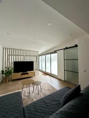 a living room with a couch and a flat screen tv at Beach, please! in Quarteira
