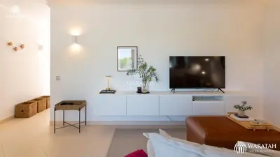 a living room with a flat screen tv on a white wall at Apartment Lamine in Loulé