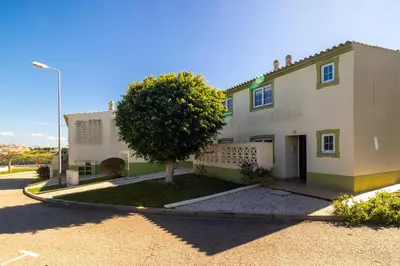 a white kitchen with white cabinets and appliances at Ponta Grande Resort - Villa Coral in Albufeira