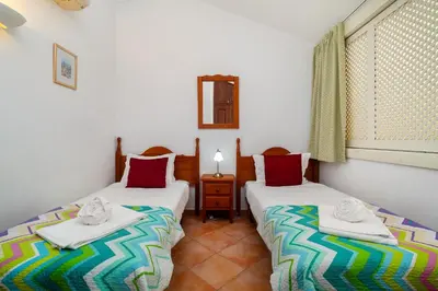 a bedroom with a large bed with towels on it at Ponta Grande Resort - Villa Coral in Albufeira