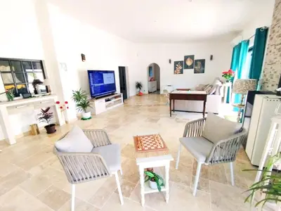 a living room with chairs and a flat screen tv at Quinta Azul in Loulé