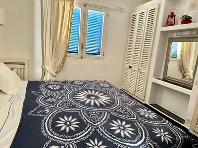 a bedroom with a bed with a blue and white blanket at Balaia Gardens in Albufeira in Albufeira