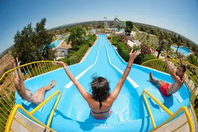 a group of people jumping into a swimming pool at a resort at Bright & Stylish 2bedflat 5min Walk to beach in Quarteira Vilamoura in Quarteira