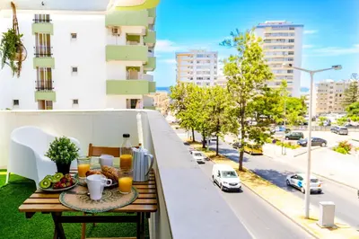 a breakfast table on a balcony with a view of a city at Bright & Stylish 2bedflat 5min Walk to beach in Quarteira Vilamoura in Quarteira