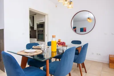 a dining room with a glass table and blue chairs at Villa Maria, 3BD & Pool & Garden & BBQ in Albufeira