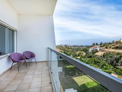 a balcony with two chairs and a view at Villa Maria, 3BD & Pool & Garden & BBQ in Albufeira