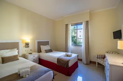 a hotel room with two beds and a window at Apartamento Vitoria in Vilamoura