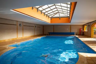 a large indoor swimming pool with a skylight at Apartamento Vitoria in Vilamoura