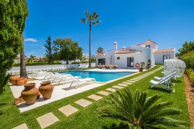 a villa with a swimming pool and a resort at Villa Veiga - Luxury modern design with large beautiful garden in Albufeira