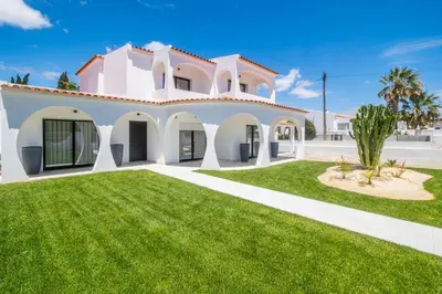 a large white house with a green lawn at Villa Veiga - Luxury modern design with large beautiful garden in Albufeira