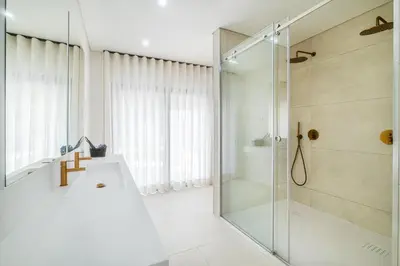 a bathroom with a shower and a sink at Villa Veiga - Luxury modern design with large beautiful garden in Albufeira