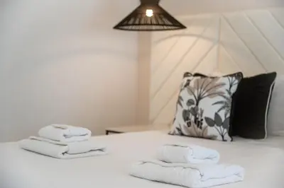 a bed with white towels on it with a pillow at Villa Veiga - Luxury modern design with large beautiful garden in Albufeira