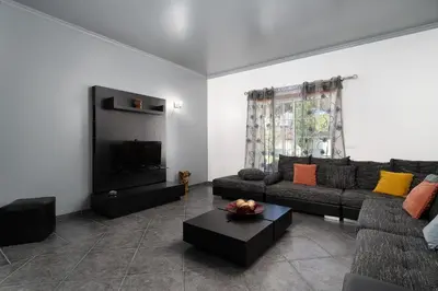 a living room with a couch and a tv at Casa Coelho in Albufeira