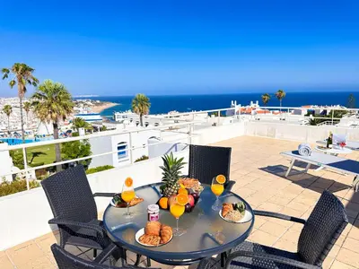 a table with food and drinks on a balcony at Stunning Sunrise & Sunset Rooftop Condo by BeCherish in Albufeira