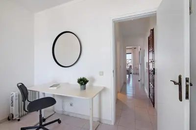 a white room with a desk and a mirror at 1 Bedroom Seaview Apartment in Quarteira