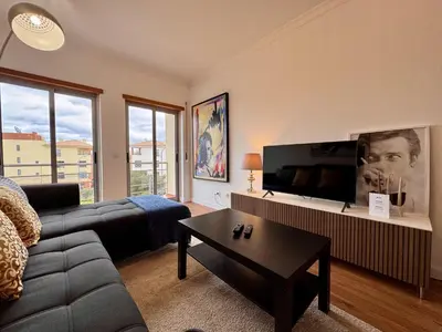 a living room with a blue couch and a tv at Albufeira Modern 6 With Pool by Homing in Albufeira
