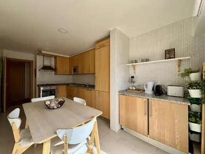 a kitchen with wooden cabinets and a stove top oven at Albufeira Modern 7 With Pool by Homing in Albufeira