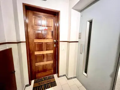 a hallway with a wooden door and a tile floor at Quarteira Brightness by Homing in Quarteira