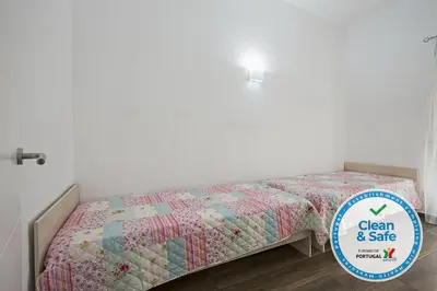 a bed with a quilt and a sign that says clean and safe at DownTown Albufeira beach Apartment in Albufeira