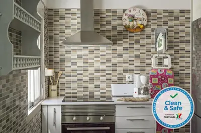 a kitchen with a stove and a sign that says clean and safe at DownTown Albufeira beach Apartment in Albufeira