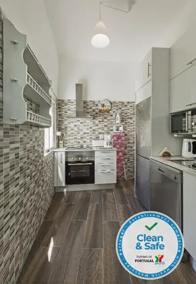 a kitchen with stainless steel appliances and wooden floors at DownTown Albufeira beach Apartment in Albufeira