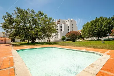 a swimming pool in front of a building at BeGuest Oura Vilanova Apartment in Albufeira
