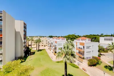 an aerial view of an apartment complex with palm trees at T1 Edificio Loulé - centro de Vilamoura in Vilamoura