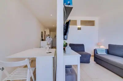 a living room with a white table and a couch at T1 Edificio Loulé - centro de Vilamoura in Vilamoura