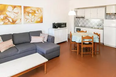 a living room with a couch and a table and a kitchen at BeGuest Sea Breeze Apartment in Albufeira