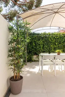 a patio with a table and chairs under an umbrella at BmyGuest - Vilamoura Golf Villa in Vilamoura
